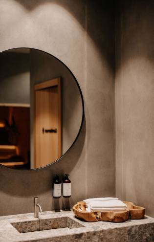 Badezimmer mit großem Spiegel und Steinwaschbecken