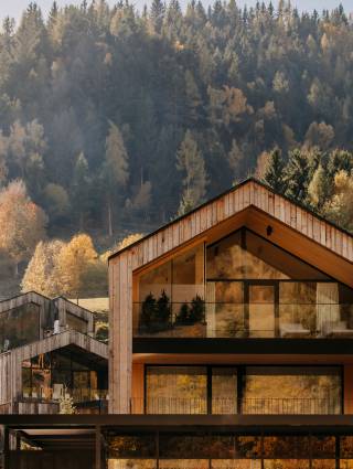 Naturhotel Forsthofgut vor den Bergen und Wäldern