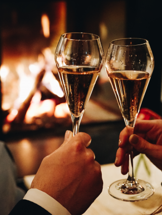 Champagne toast in front of an open fireplace