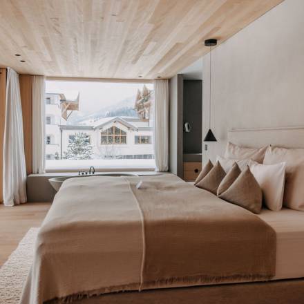 Master Bedroom mit winterlichem Blick auf das Naturhotel Forsthofgut