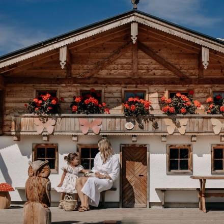 Mother and daughter enjoy the sunny day at miniGUT, the farm at Naturhotel Forsthofgut.