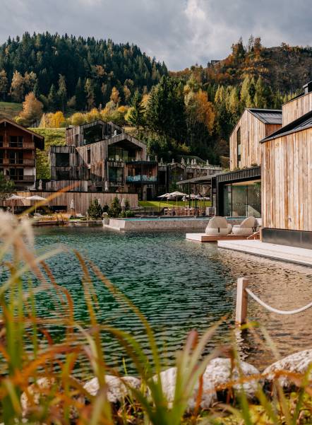 Badesee und Seehaus mit Blick auf die Berge im frühen Herbst