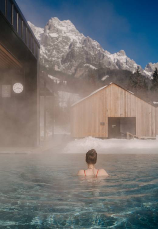 Frau schwimmt im Outdoor Pool im Winter