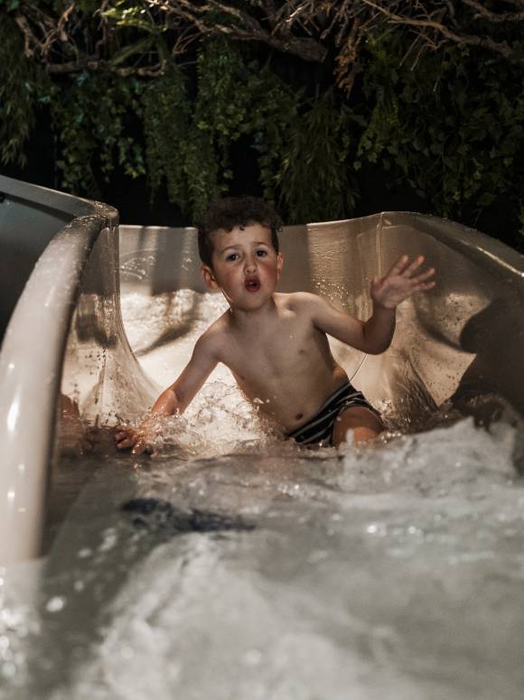 Family and kids spa area kid uses waterslide