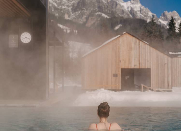 Frau schwimmt im Outdoor Pool im Winter