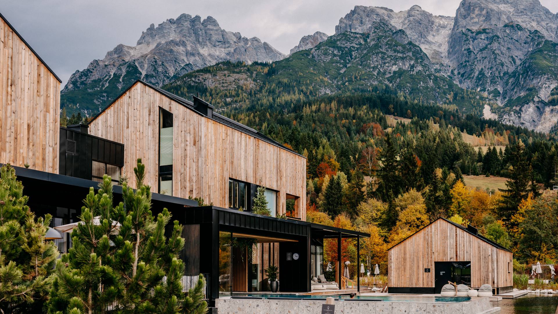 Seehaus und Außenpools mit Ausblick auf die Berge in Leogang